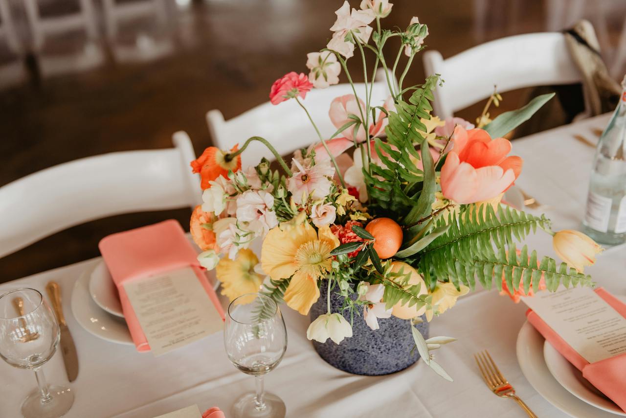 テーブルの上に装花とお皿とグラスと、カトラリーがコーディネートされている