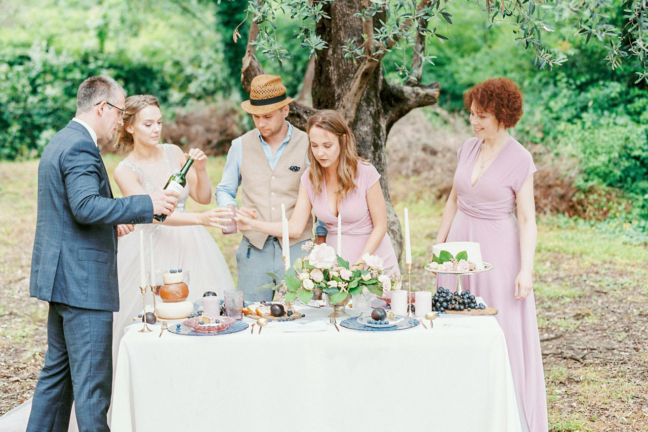 ケーキや装花が並べられているテーブルの周りに集まっている新郎新婦とゲスト